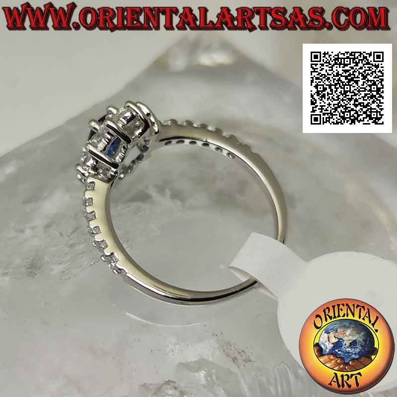 Anillo de plata con flor de circonita blanca engastada con zafiro sintético ovalado y circonita en los lados