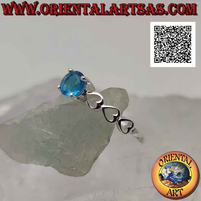 Solitaire silver ring with round synthetic blue topaz set and perforated hearts on the sides