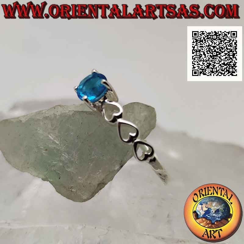 Anillo solitario de plata con topacio azul sintético redondo engastado y corazones perforados en los laterales