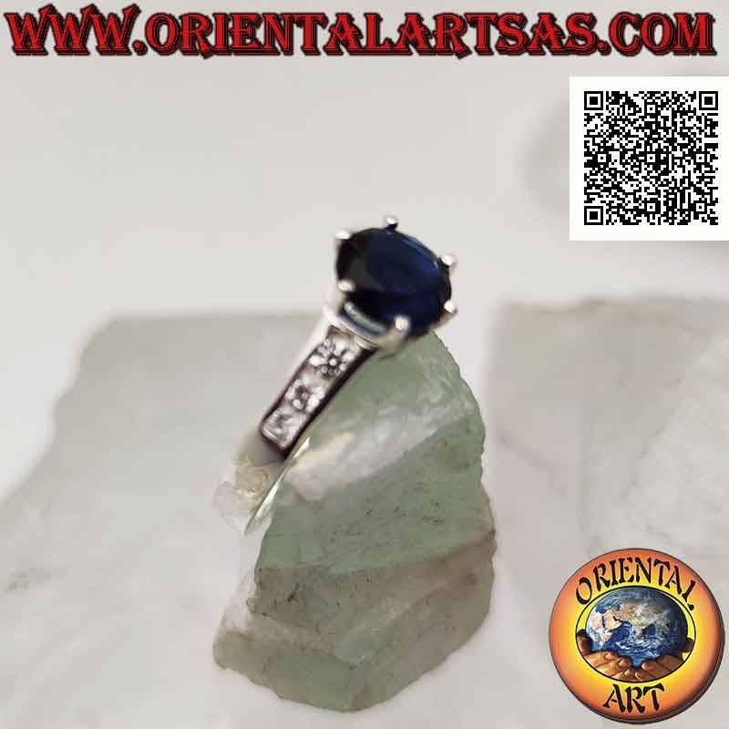 Anello in argento solitario con zaffiro di sintesi tondo incastonato in rilievo e zirconi sui lati