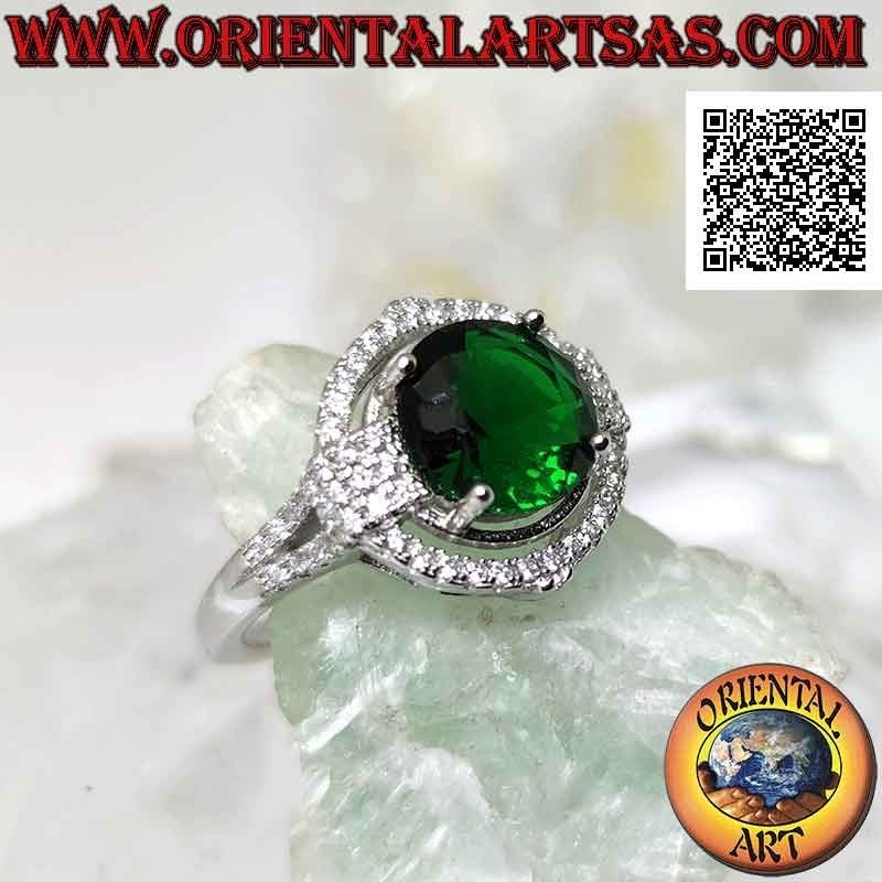 Anillo de plata con esmeralda sintética redonda engastada rodeada de circonitas con relieve en los puntos cardinales
