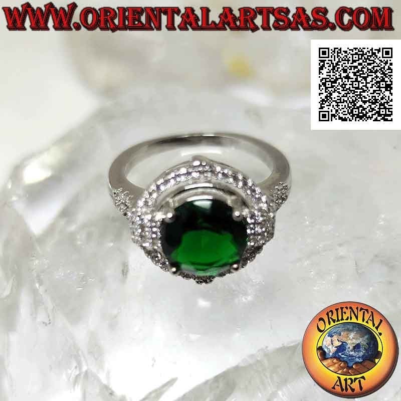 Anillo de plata con esmeralda sintética redonda engastada rodeada de circonitas con relieve en los puntos cardinales