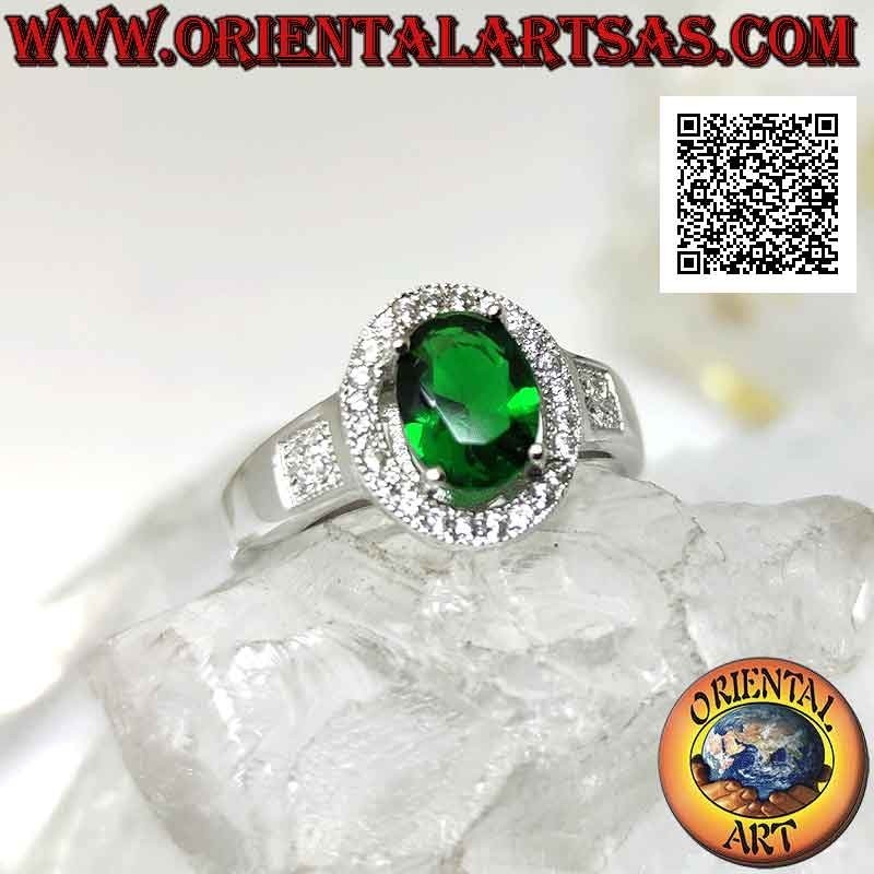 Anillo de plata con esmeralda sintética ovalada engastada rodeada de circonitas y cuadrada en los laterales