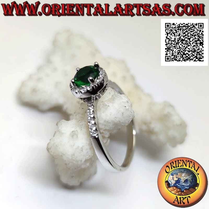 Anillo de plata con esmeralda sintética redonda engastada rodeada de circonitas blancas y en los laterales