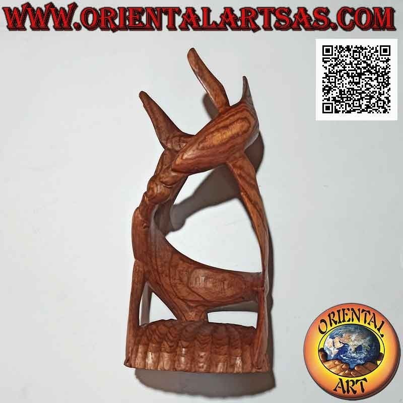 Portabottiglie scultura di una coppia di delfini a spirale in gioco avvolgente in legno di suar