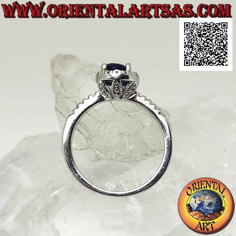 Silver ring with round synthetic sapphire set surrounded by white zircons and on the sides