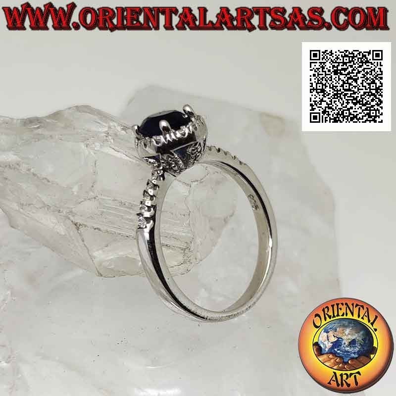 Silver ring with round synthetic sapphire set surrounded by white zircons and on the sides