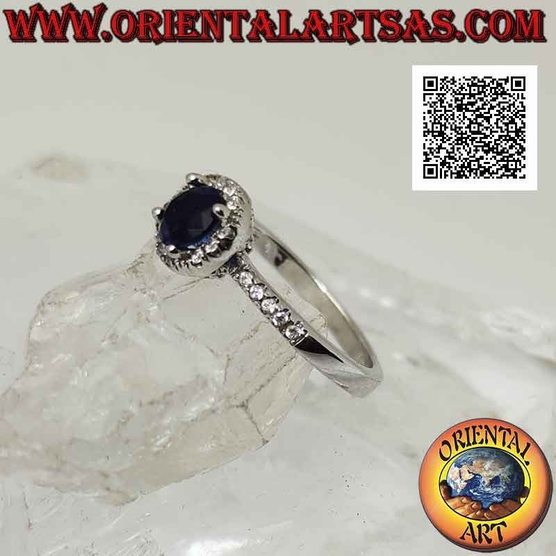 Silver ring with round synthetic sapphire set surrounded by white zircons and on the sides