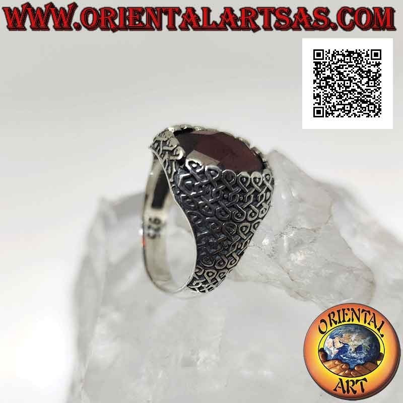 Silver ring with faceted oval garnet and geometric series of intertwined infinities on the sides