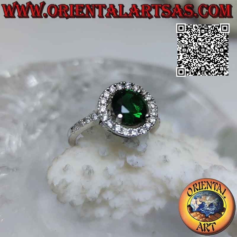 Anillo de plata con esmeralda sintética redonda engastada rodeada de circonitas y extensión en los laterales