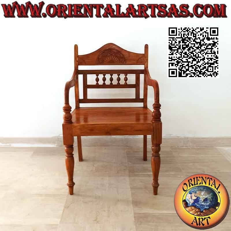 Butaca con rosetón tallado y columnitas sobre respaldo de madera de teca