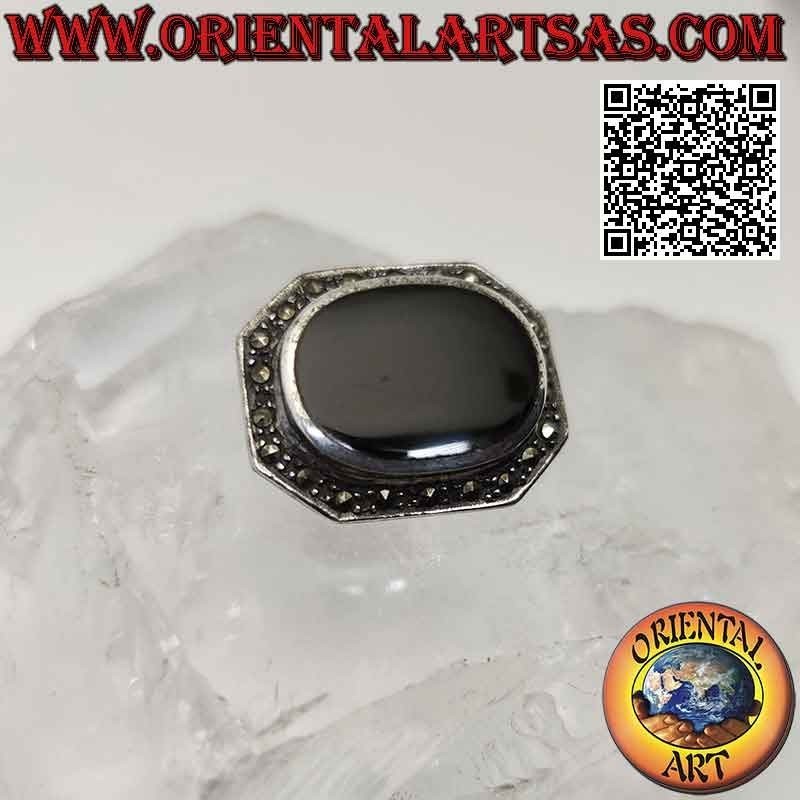 Silver brooch in the shape of an elongated octagon with a large oval onyx surrounded by marcasite
