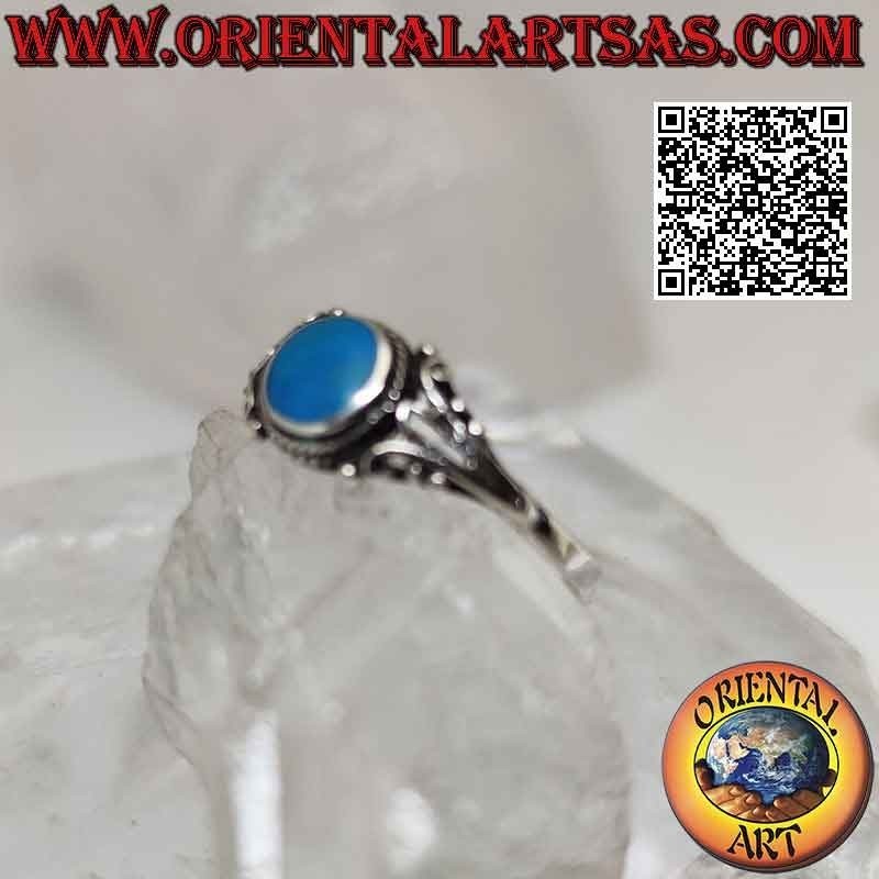 Bague en argent avec turquoise ronde entourée d'entrelacs et décoration florale en filigrane sur les côtés
