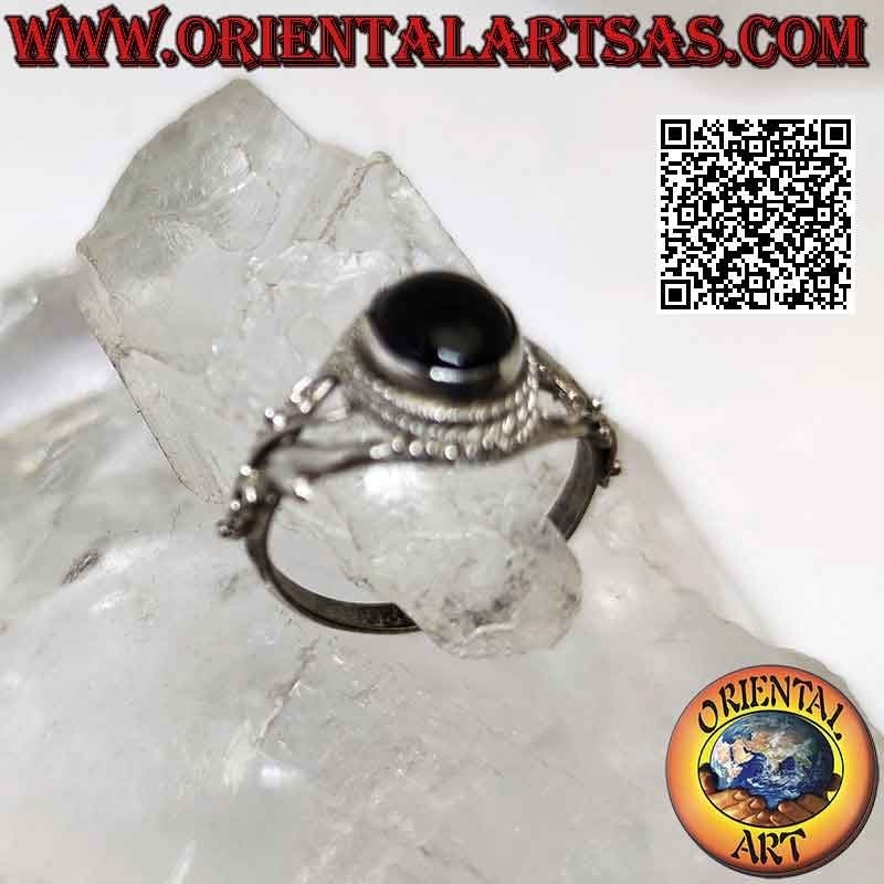 Silver ring with oval cabochon onyx surrounded by balls and threadlike floral decoration on the sides