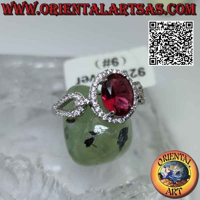 Silver ring with oval garnet set surrounded by white zircons and hooked on the sides