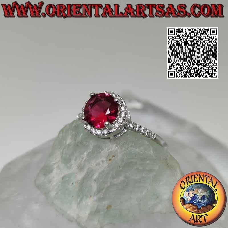 Anillo de plata con rubí sintético redondo engastado rodeado de circonitas y extensión en los laterales