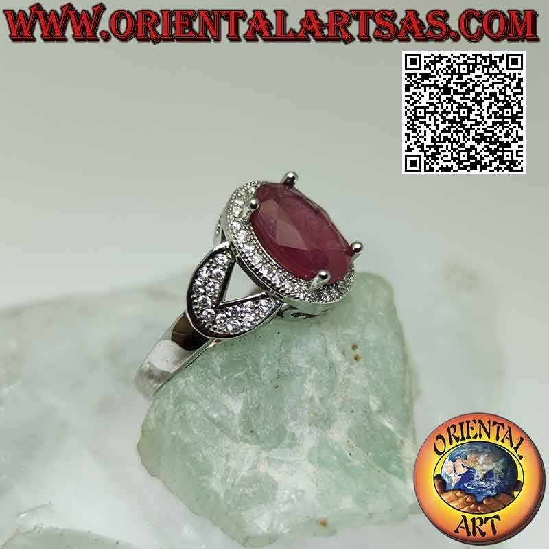 Anillo de plata con gran rubí natural ovalado engastado rodeado de circonitas y enganchado a dos en los laterales