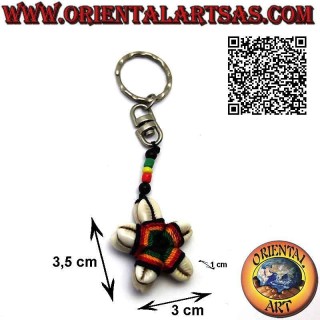 Metal keychain with a star of cauri shells knotted in the center and colored beads