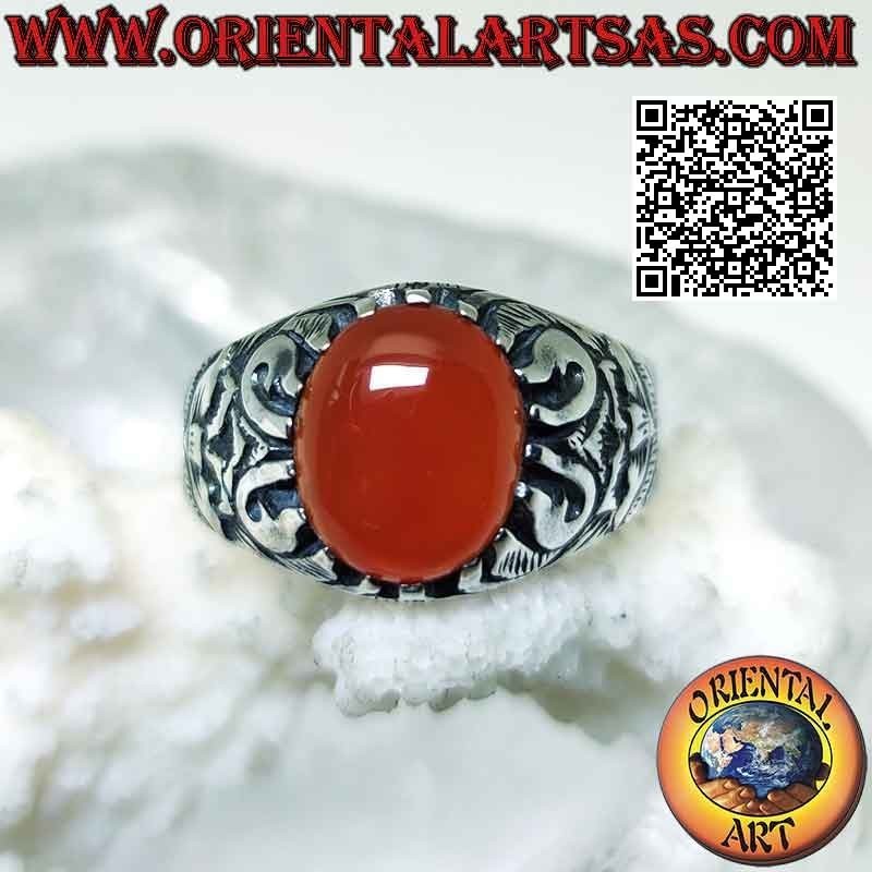 Bague en argent sertie d'un cabochon ovale en cornaline et d'un décor mystique en bas-relief