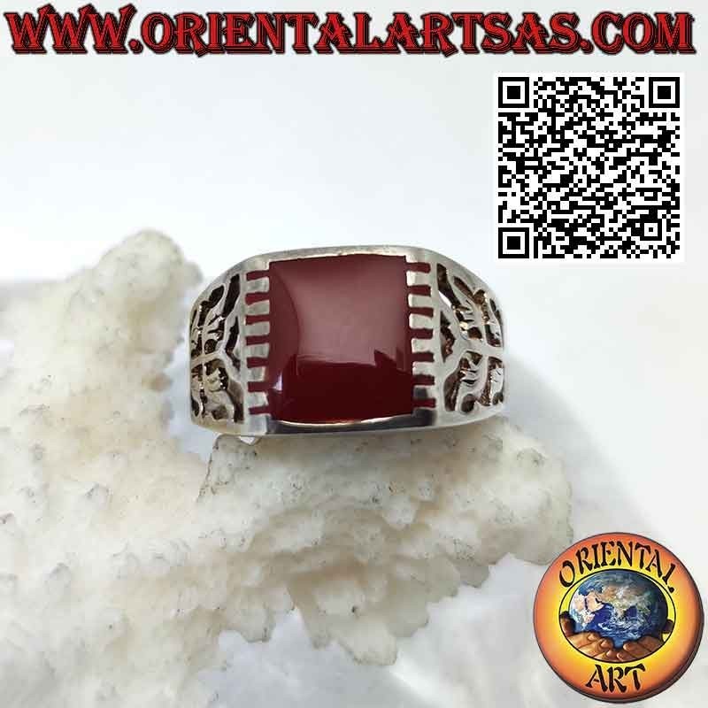 Anillo de plata con cornalina rectangular enganchada lateralmente y motivo curvo sobre fondo perforado
