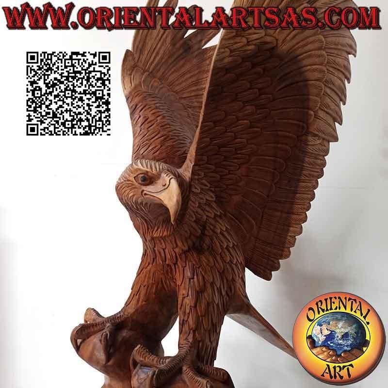 Escultura de águila real con las alas extendidas de pie sobre el promontorio de madera de suar de 80 cm.