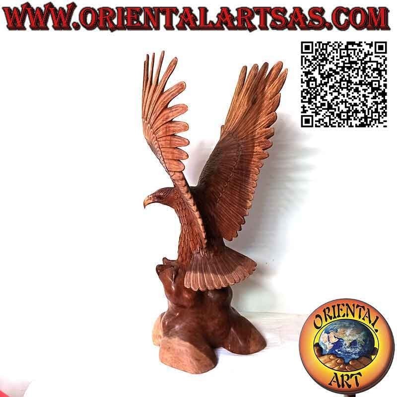 Escultura de águila real con las alas extendidas de pie sobre el promontorio de madera de suar de 80 cm.