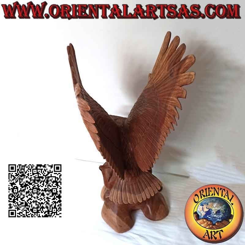 Escultura de águila real con las alas extendidas de pie sobre el promontorio de madera de suar de 80 cm.