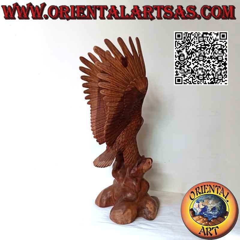 Escultura de águila real con las alas extendidas de pie sobre el promontorio de madera de suar de 80 cm.