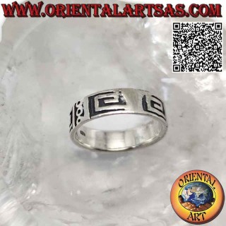 Bague en argent travaillée avec une série de spirales et de cercles carrés lisses sur un fond lisse