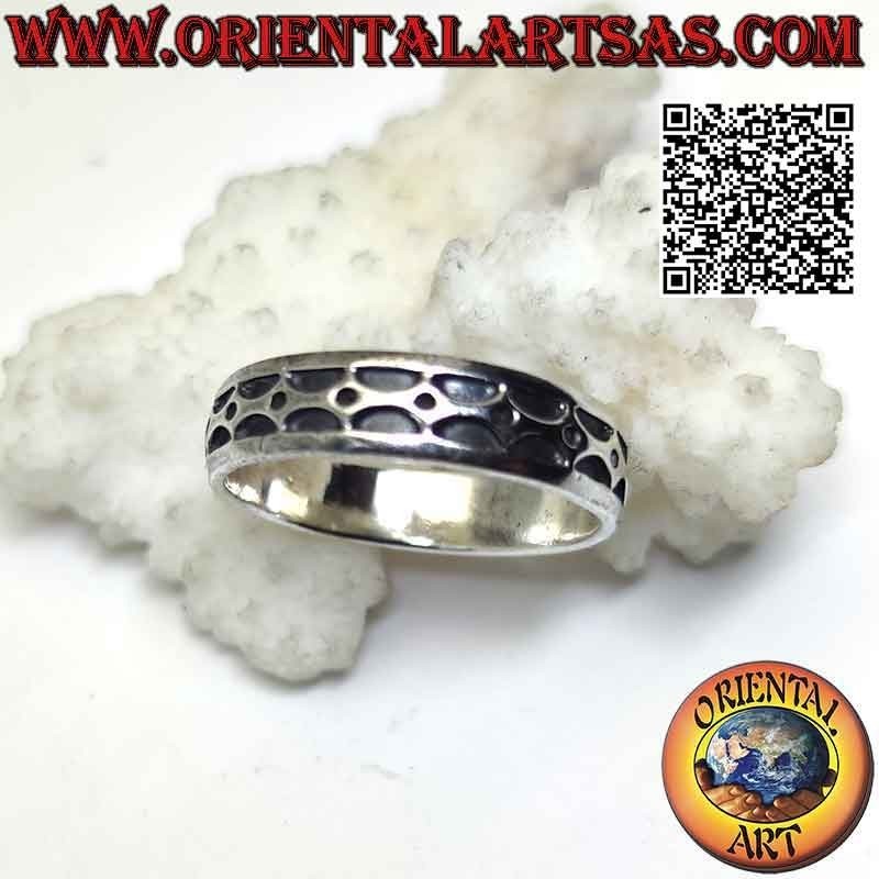 Anillo de plata trabajado con una serie de semicírculos opuestos con grabado profundo y una bola entre ellos.