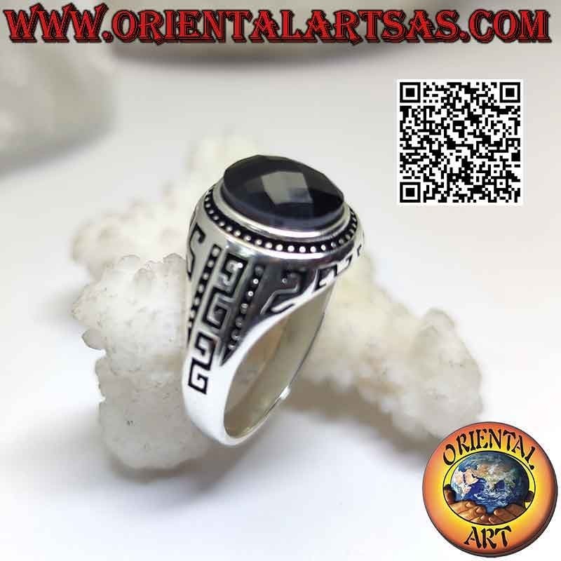 Anillo de plata con espinela oval facetada y greca grabada en los laterales