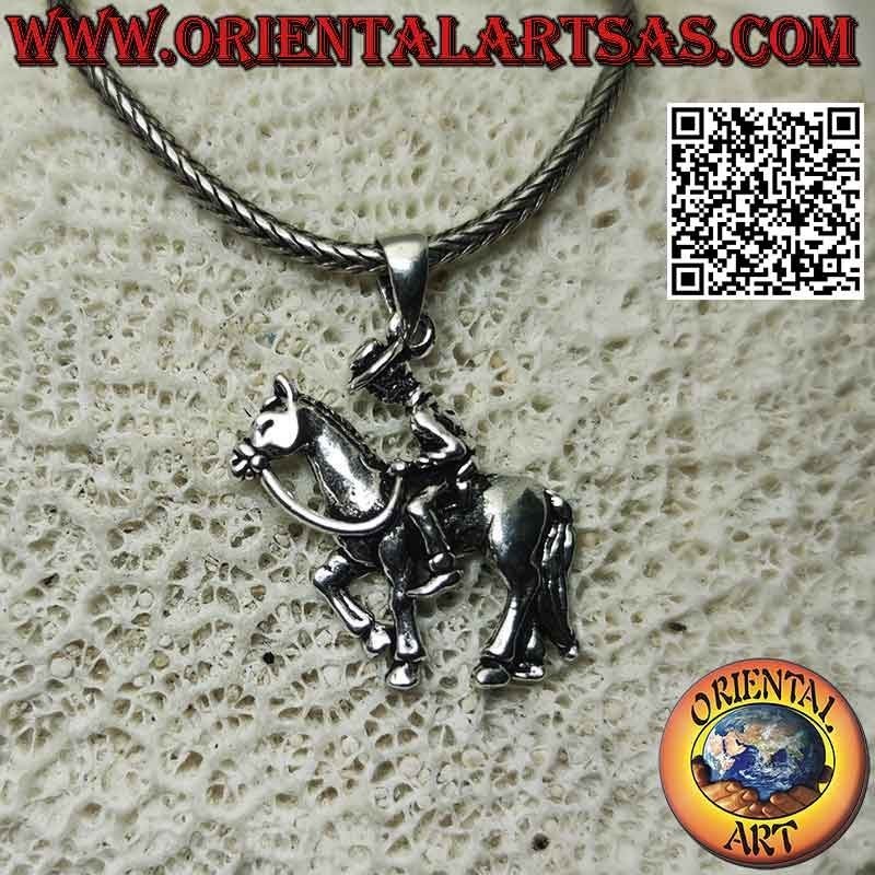 Silver pendant in the shape of a cowboy on horseback (profile)