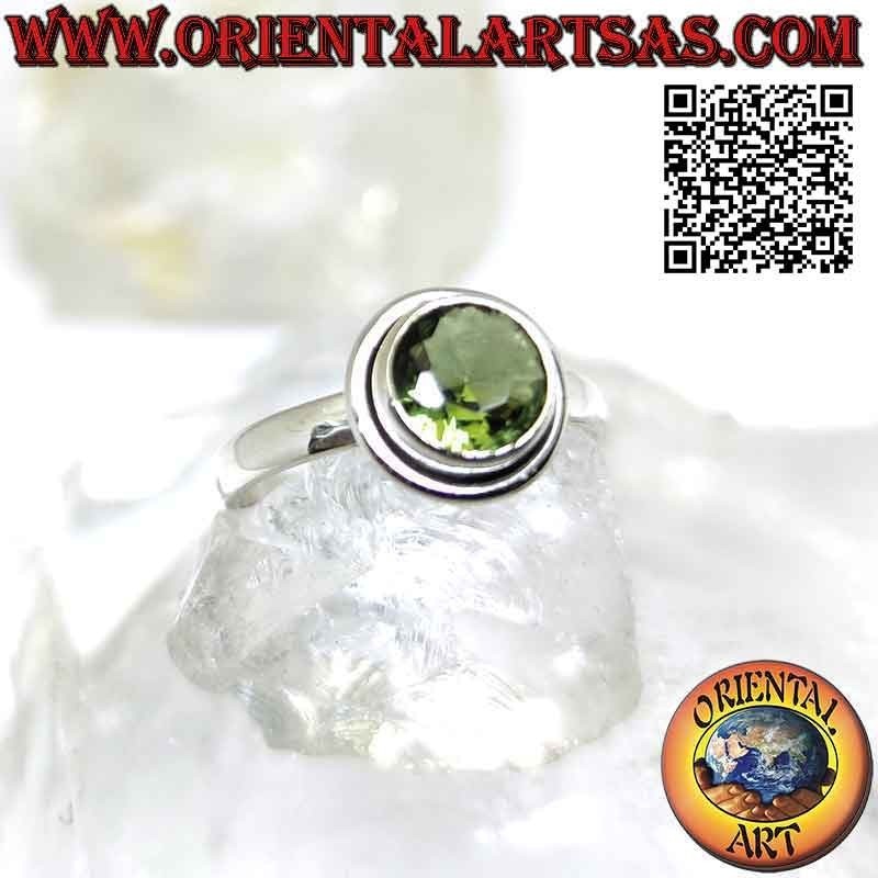 Anillo de plata con un peridoto redondo facetado en relieve con un borde saliente liso