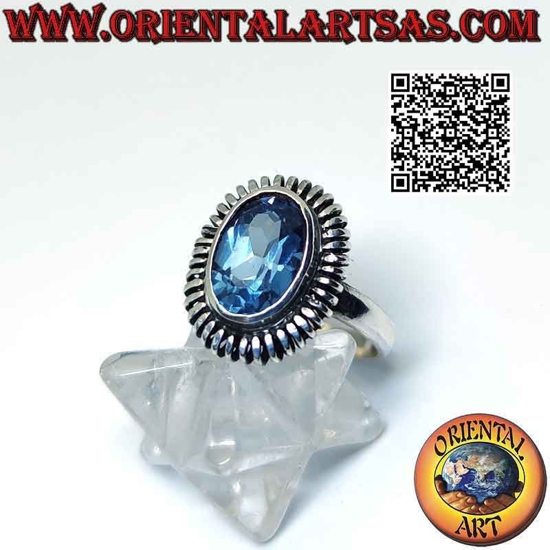Silver ring with oval blue topaz surrounded by a smooth spring