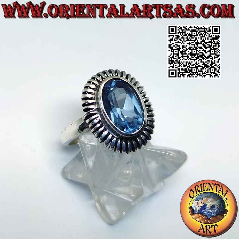 Silver ring with oval blue topaz surrounded by a smooth spring