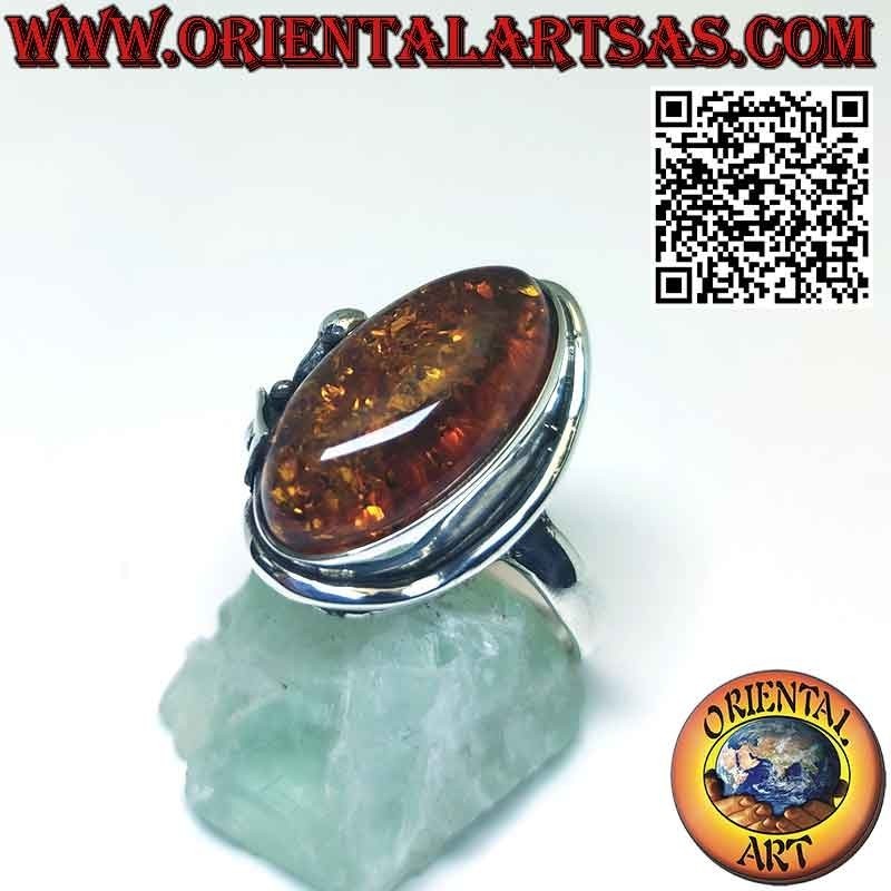 Anillo de plata con gran ámbar ovalado y flor de lirio en un lado