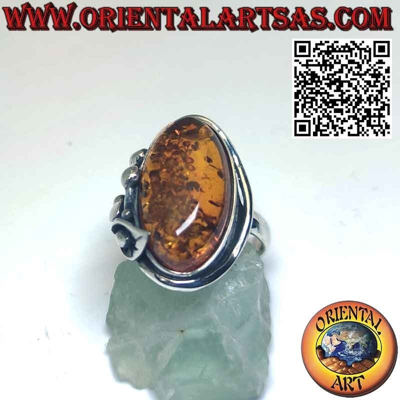Anillo de plata con gran ámbar ovalado y flor de lirio en un lado