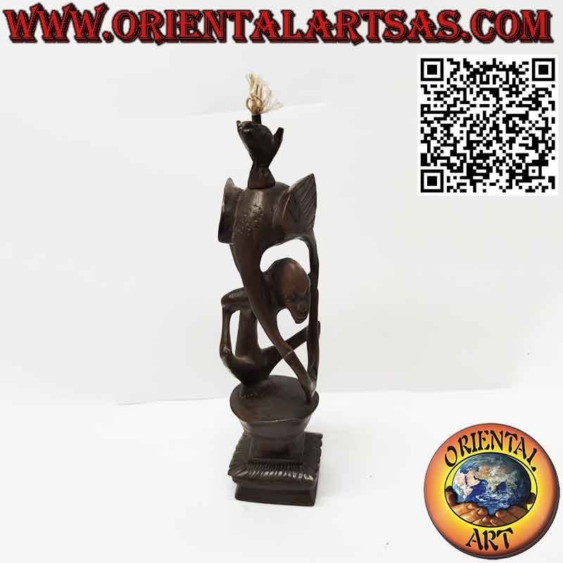 Rara escultura de ébano de un hombre, un pelícano y un murciélago iluminado