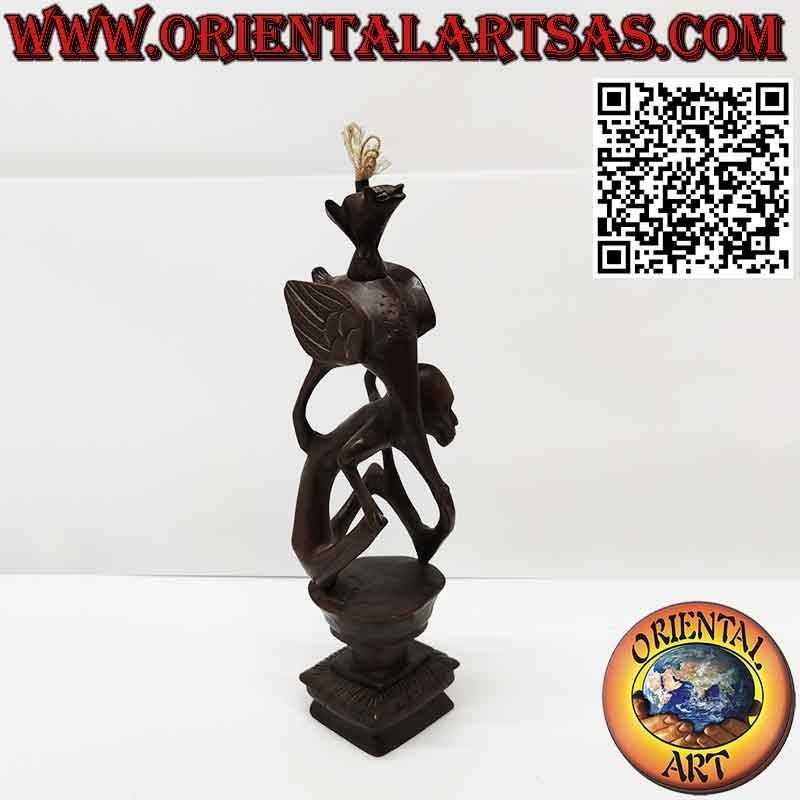 Rara escultura de ébano de un hombre, un pelícano y un murciélago iluminado