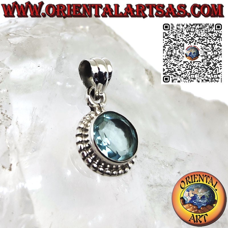 Colgante de plata con topacio azul redondo rodeado de puntos.