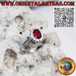 Anillo de plata con granate ovalado engastado y rodeado de circonitas.