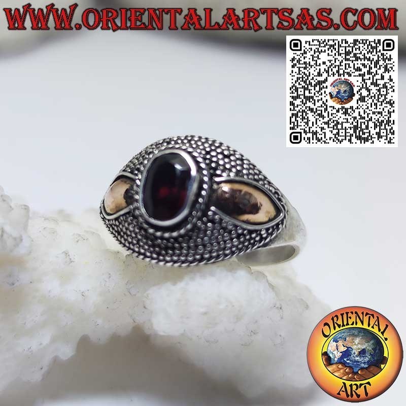 Silver ring with oval garnet and 14-karat gold plates on the sides