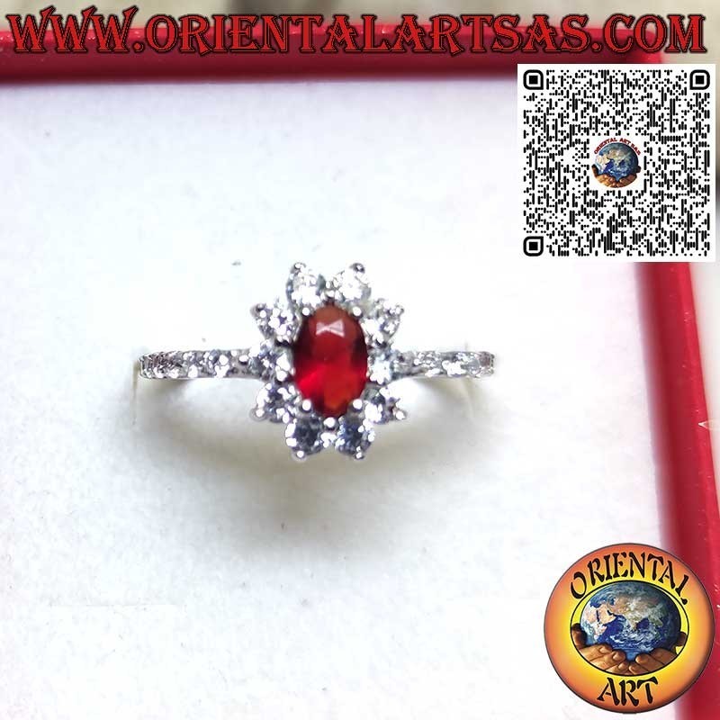 Silver ring with small oval garnet set surrounded by cubic zirconia and row on the sides