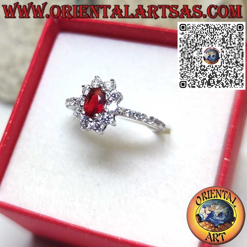 Anillo de plata con un pequeño conjunto de granate ovalado rodeado de circonitas cúbicas y una fila a los lados