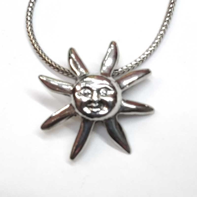 Colgante de plata lisa en forma de sol con rayos y cara